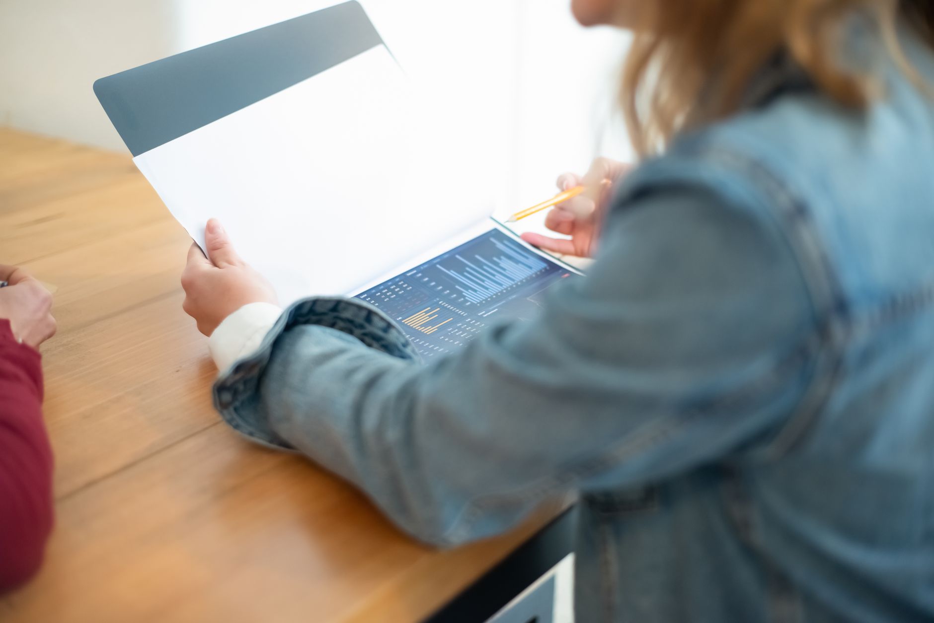 a person reviewing a credit report on a tablet at a desk with documents nearby