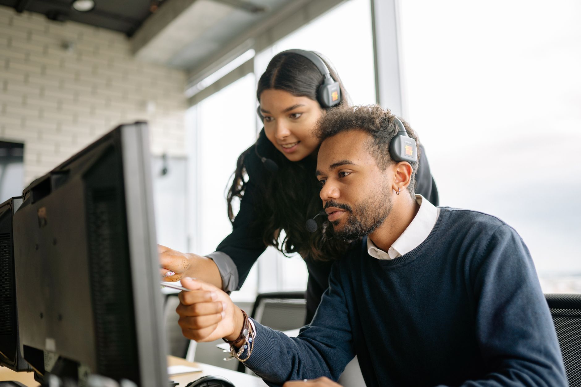 support agent wearing a headset and reviewing account recovery details on a computer