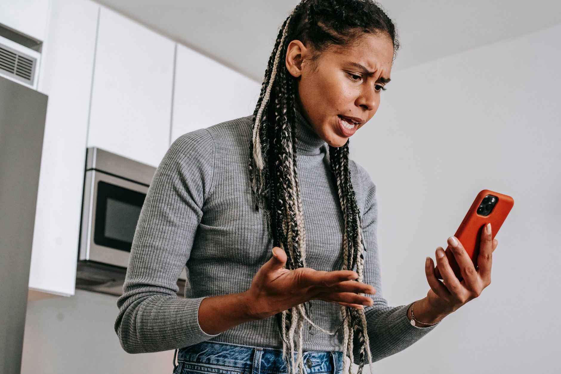 Woman looking at her phone with a worried expression while using a dating app