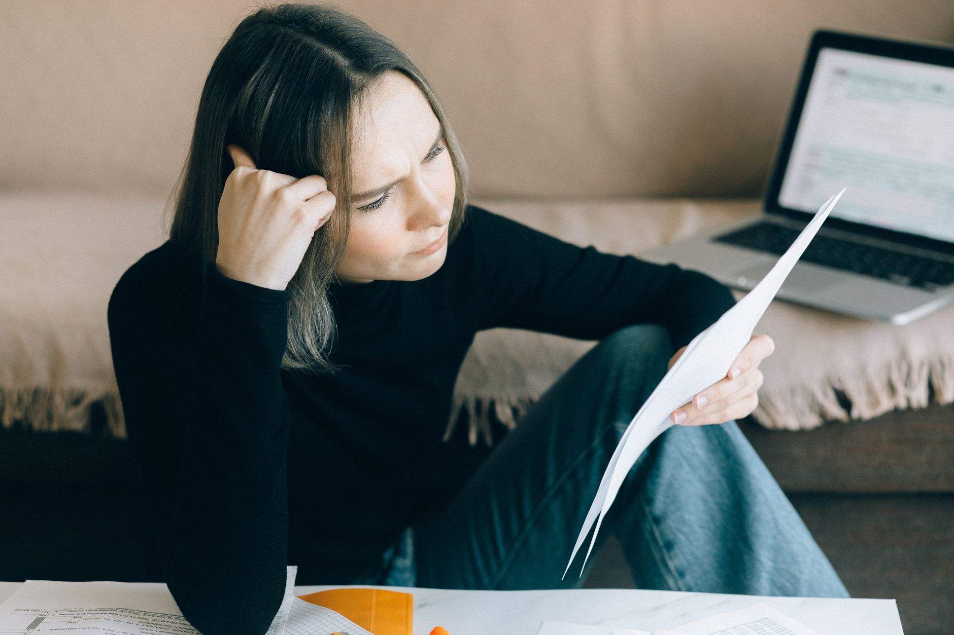 a person reviewing a credit report on a laptop with a freeze notice on the desk