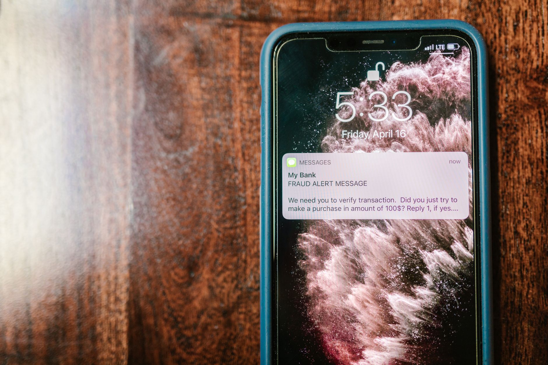a smartphone displaying a bank fraud alert notification on its home screen